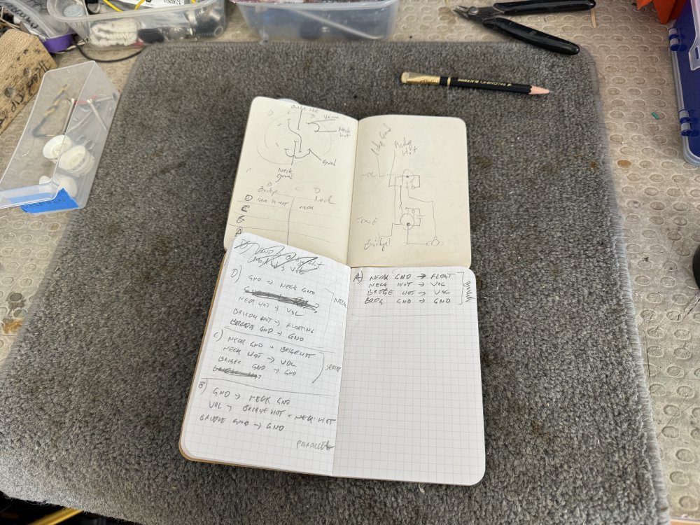 A photo of two note books, one showing the original diagram shown a few photos back, and the other with a table written in handwriting explaining what wires do what for each switch position.