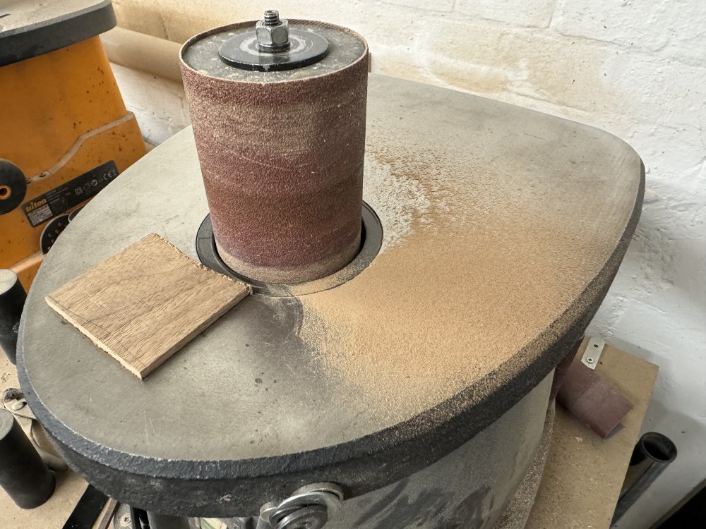 A photo of a spindle-sander with a block of rosewood on it, and a lot of rosewood-dust.