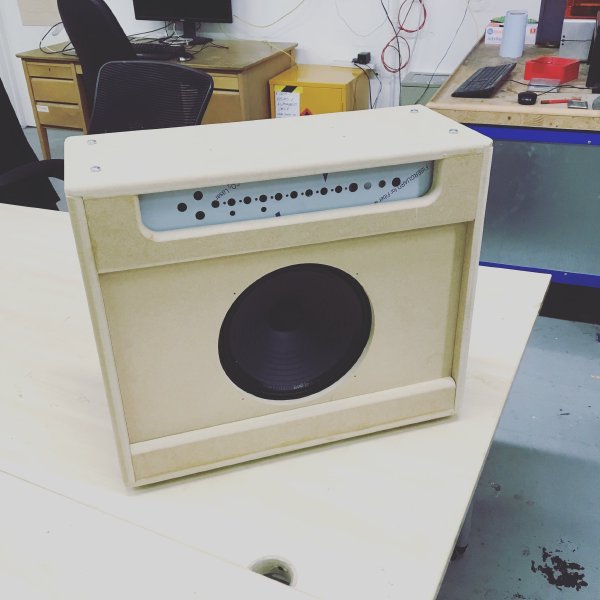 A photo of an unfinished amp combo cabinet that has been built. The speaker and metal component tray are in place, but the body is just raw MDF and needs painting. The photo makes it look just like the CAD model, only more real.