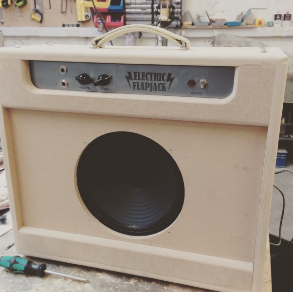 The amp cabinet sits on the workbench, all assembled, but with no outer finishing, so you can see it is made from MDF, and has a 10 inch speaker.