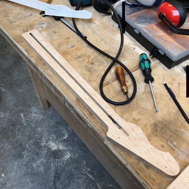 A bit of birds-eye maple that now has the outer shape of a guitar neck, but is otherwise still very much plank-like. There is a channel routed out in the top in which sits a truss-rod.