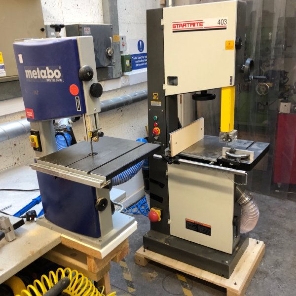 A photo of the new floor-sanding large Startrite bandsaw with the older bench-mounted Metabo bandsaw beside it.
