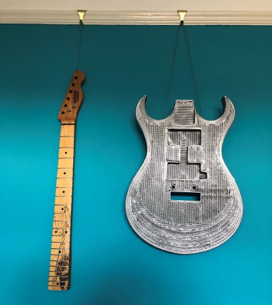 Hung on the wall of my study is the original guitar neck from one of my early builds, and a full sized 3D-print of a guitar body.