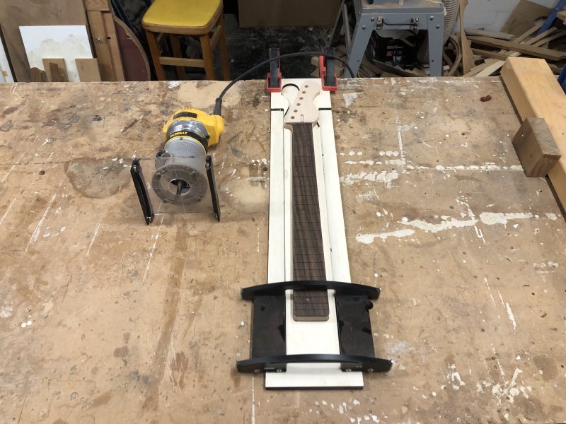 The neck in the jig, with the router sat beside it, ready to be cut.