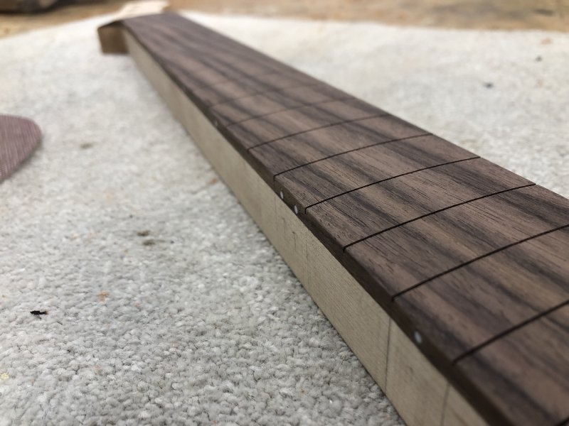 A side shot of the neck on the workbench, trying to show the subtle rounding of the fretboard on top to the side of the neck, but it's less that you can see the rouding, more that you can't see the harsh edge.