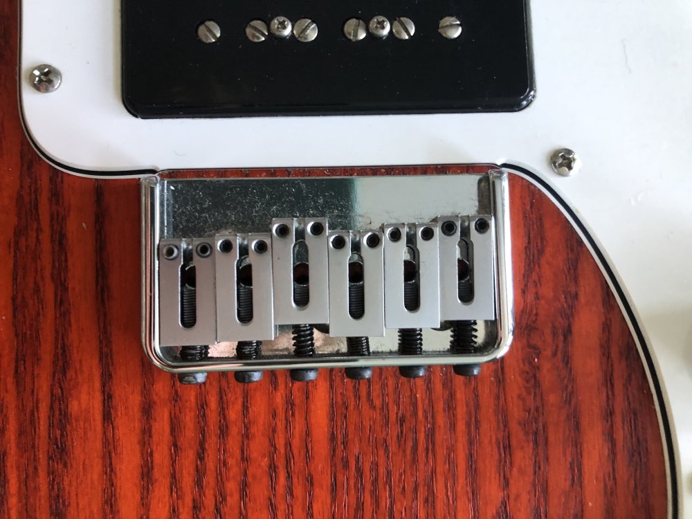 A close up of the old bridge on my Blues Deluxe guitar. You can't really tell much about the accuracy of the position from this shot, but you can see that the old bridge is a chrome-plated hard-tail bridge, where the strings are run through the body rather than being attached to the bridge itself.
