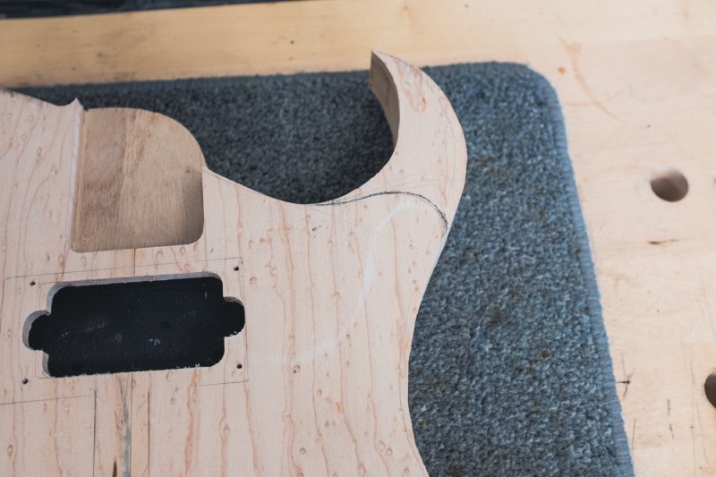The body now has a clear pencil line on it as to where the outline of the new design necessitates the removing of the right hand horn of the guitar.