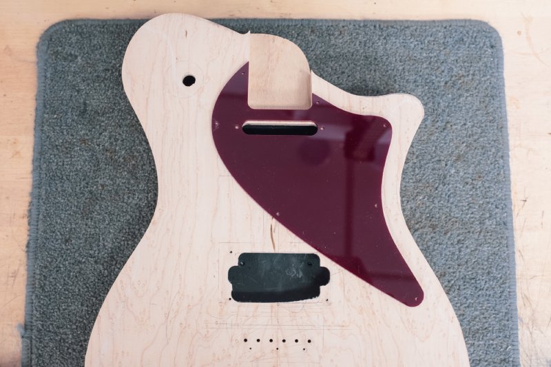 The modified body with a very swoopy pickguard placed on it. You can also see my wonky cut for one of the existing pickup holes - oops.
