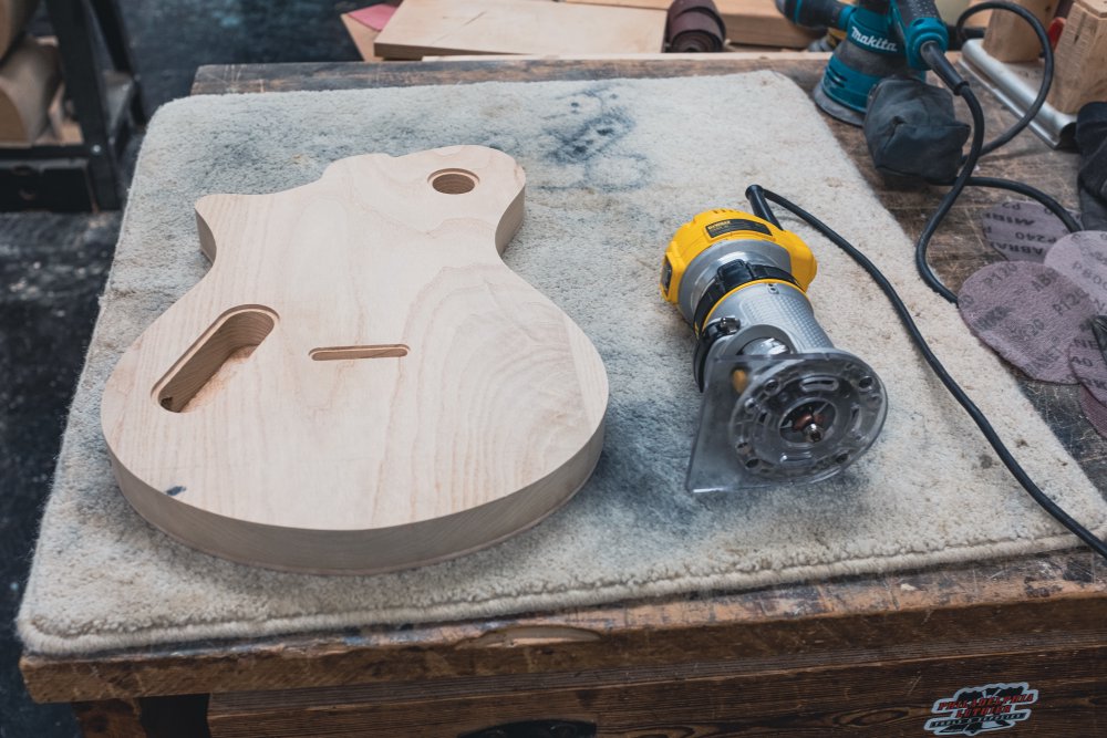 The body face down on the workbench, with a palm-router sat beside it.