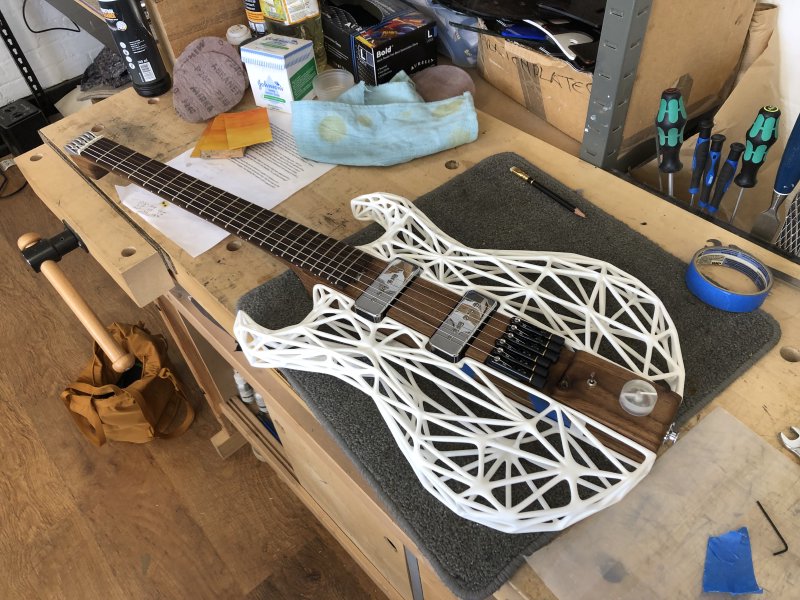 The Älgen guitar sits on my workbench, looking somewhat complete now it has a volume control installed on the tail.