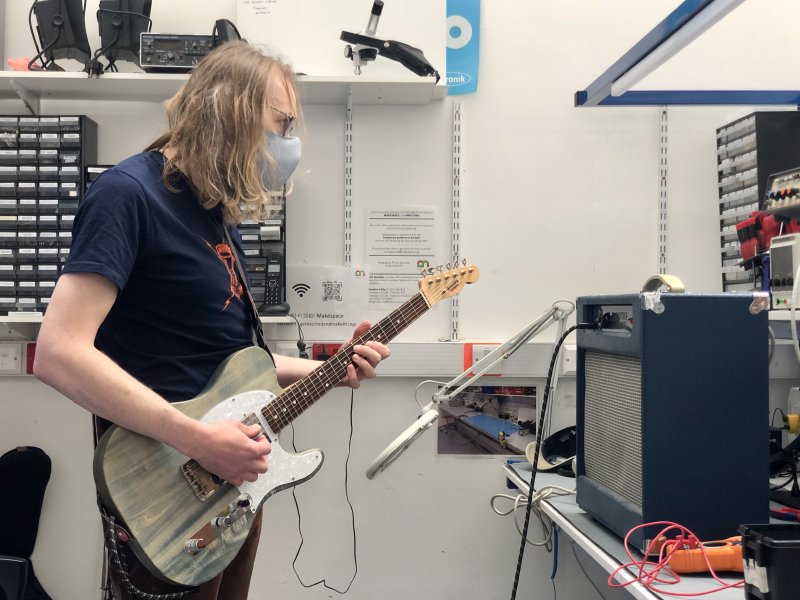 I'm stood next to the workbench with the amp on it, and I have a guitar plugged into the amp for testing purposes. I'm staring at the amp as I play.