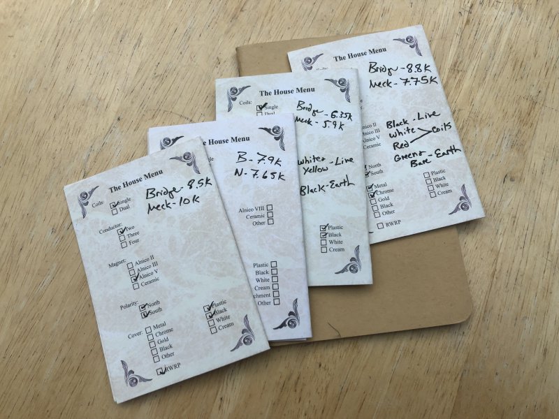 A series of small cards that have written on them the specifications for different sets of pickups, what kind of magnet was used, what the final resistance is, etc.