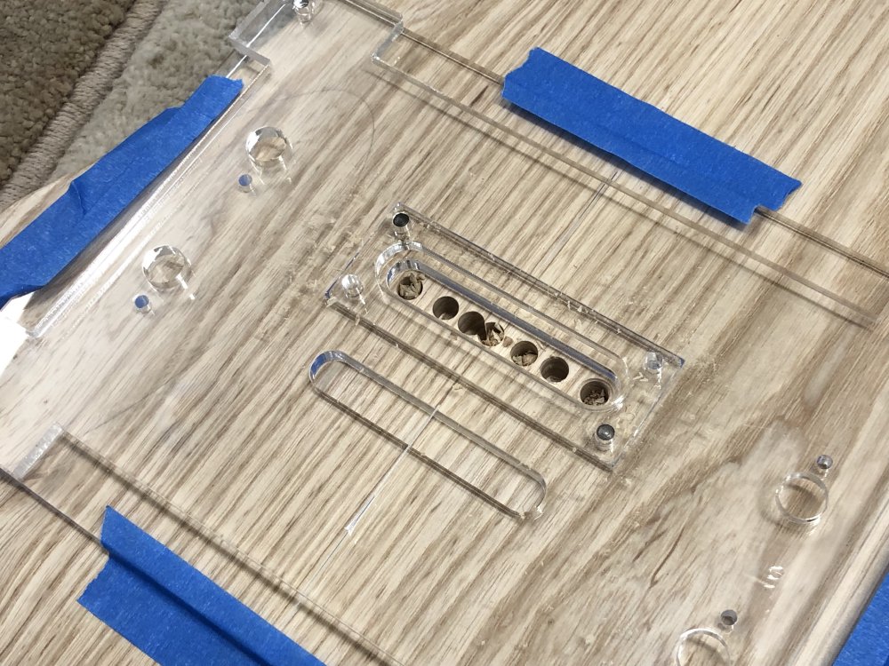 The same guitar rear with acrylic template as in the last picture, only where the template has a gap in it to guide the router, there is now a series of holes drilled into the wood.