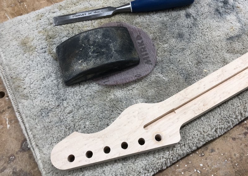 The headstock now has 6 holes in it for the tuners, all of an equal size. You can see the outline of the plug on the 6th hole.