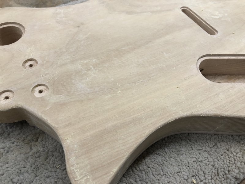 A close up of the guitar body that now looks somewhat manky with a yellowish crust in places.