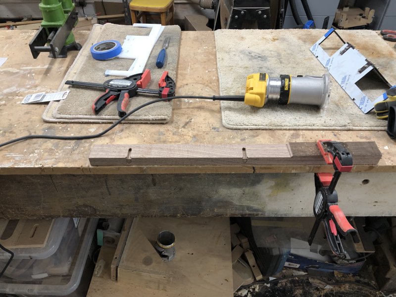 The same plank of wood in the previous pictures is seen, now without the jig and you can see two slots have been cut into it with recessed ends.
