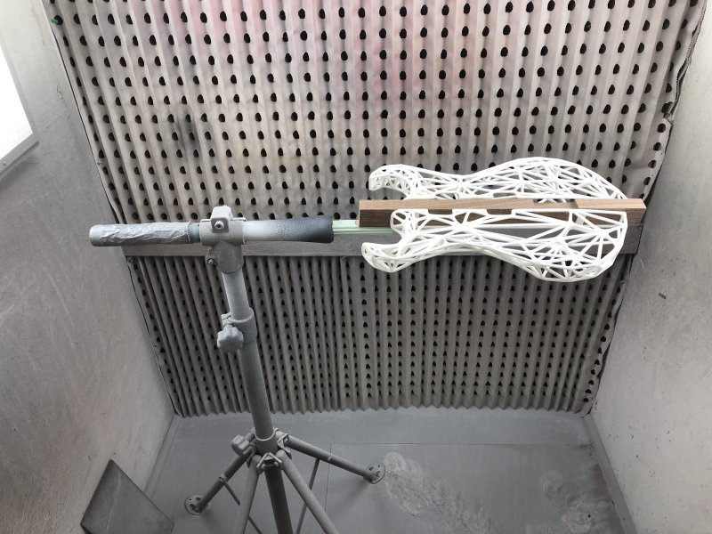In the spray booth you can now see the point of all this work: there is a clamp that holds a guitar body about a metre or so off the ground, allowing it to be sprayed evenly on all sides and rotated.