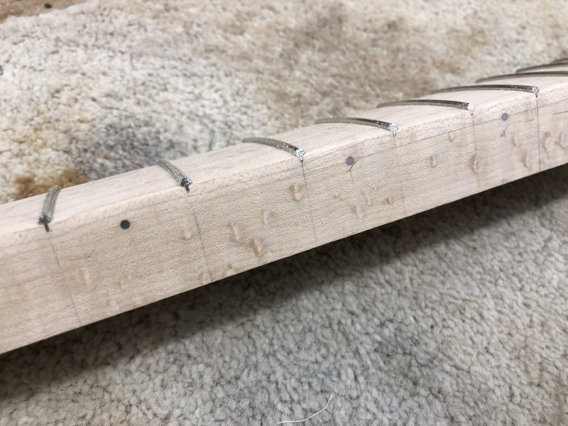 A view of the side of the neck after I've filed down the fret ends, showing they are flush with the side of the neck. You can also see the dot inlays, made from a similar material, are also flush too.