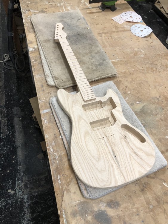 Both the neck and the body sit together, looking like an actual guitar, albeit one that hasn't been painted, or has any other parts added to it.