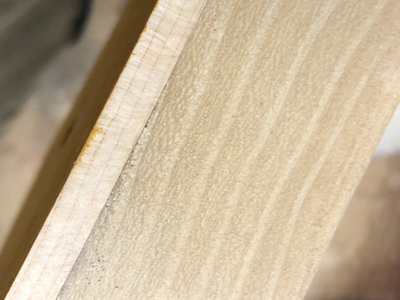 A close up on the side of the guitar body to show where the stain has gone over the edge. The bulk of the body is a generic wood, with only the top 5mm being the nice maple wood. At this point you can see just a small amount of the yellow stain from the previous picture has ended up on the side, and thus must be removed.