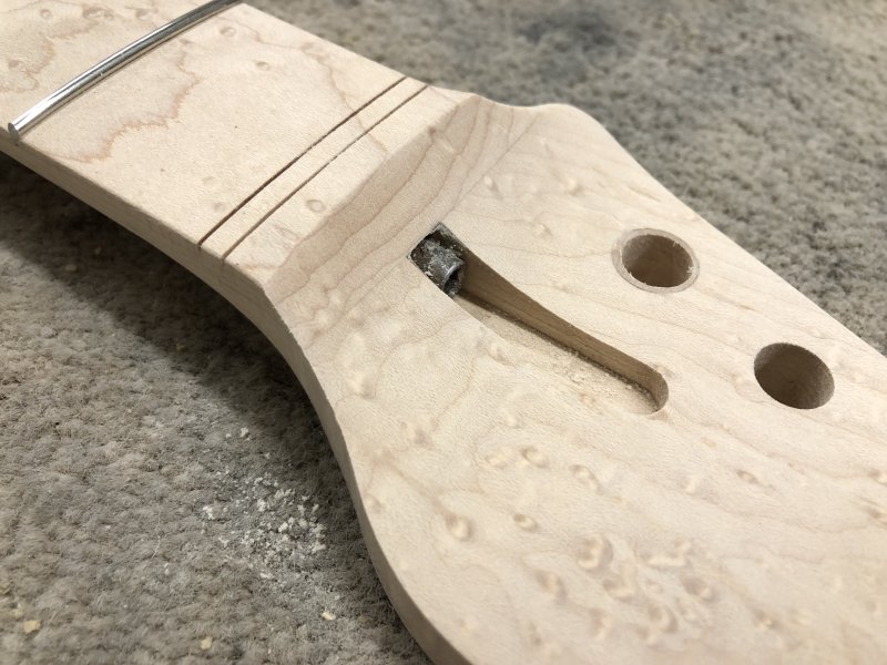 Another close up of the curve transitioning between the headstock face and the fretboard, and both the step and the nick are gone. You can however now see that there is some dried wood glue around the orders of the truss rod access channel.