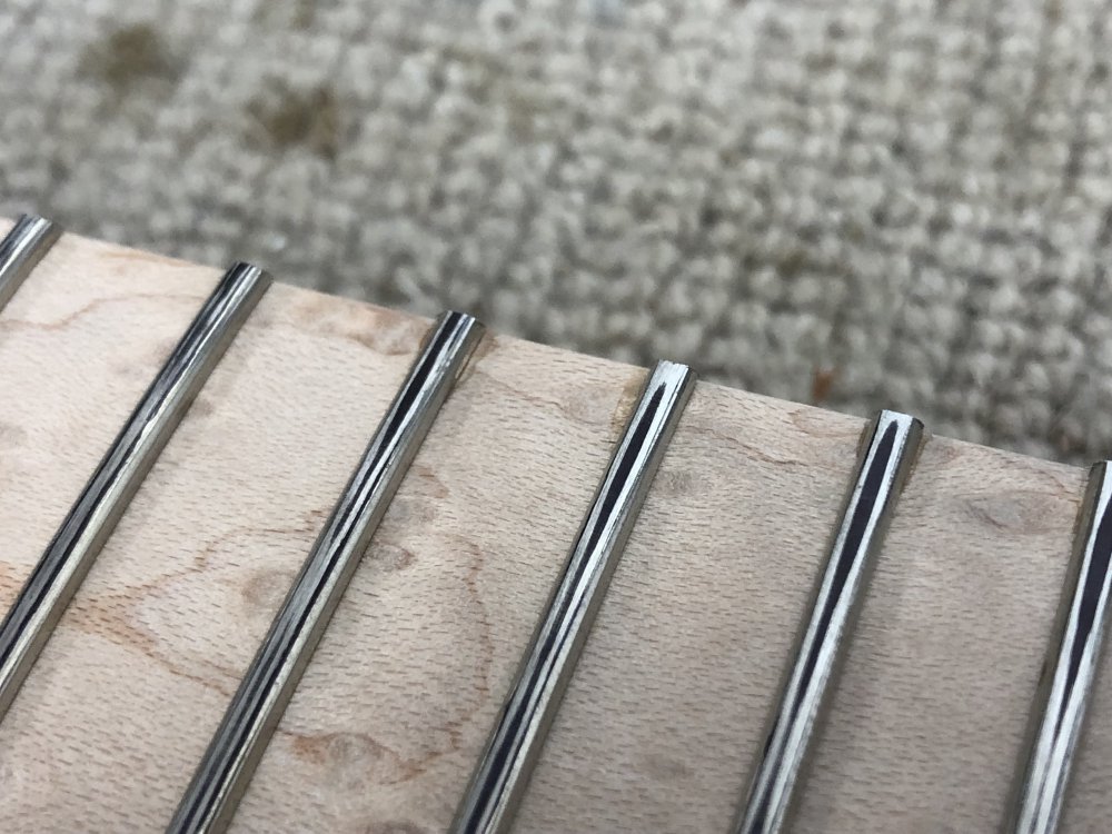 A close up of the frets again, and this time they have sharpie on them, but along the central ridge of the fret is black, with the areas either side show silver.