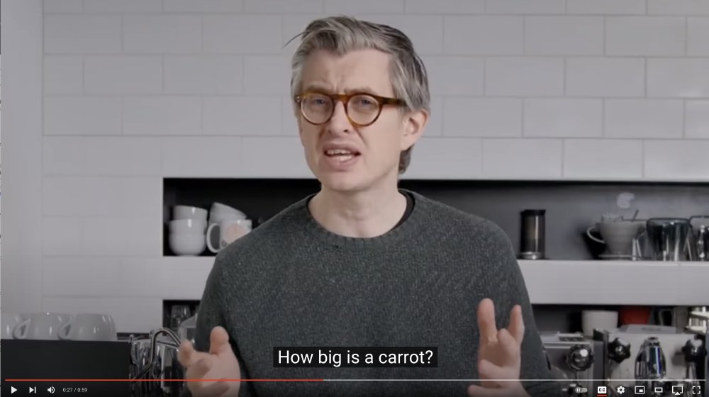 A screen shot of a James Hoffman video where he looks quite irate, and there is a subtitle caption saying 'How big is a carrot?'