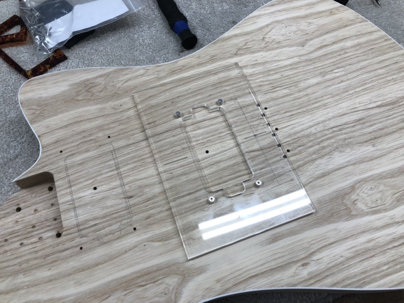 Once again we have a close up of the guitar body with the routing template over it, but this time it is secured in position by 4 torx screws.