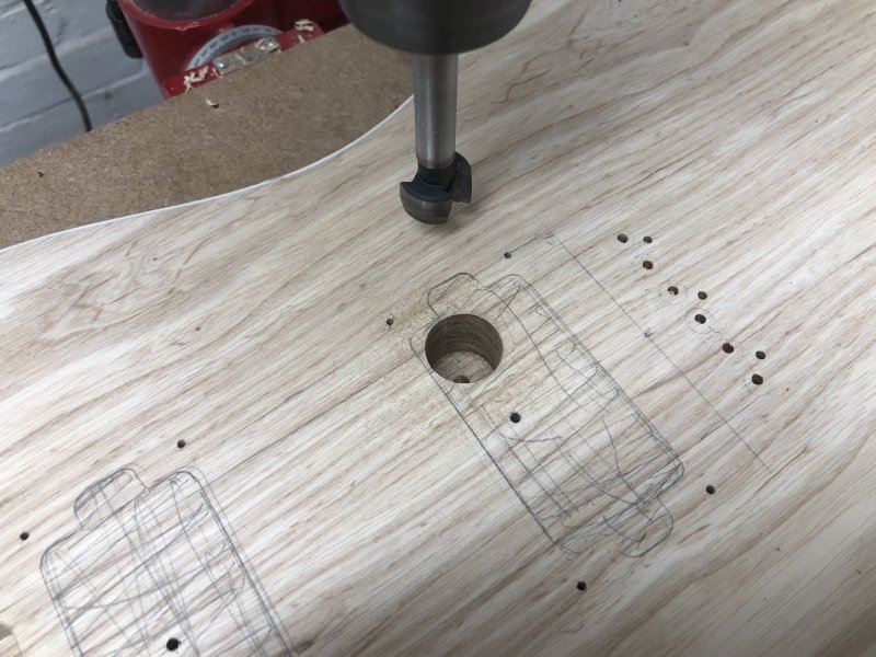 The follow on from the previous picture, with the shavings and dust removed from the top of guitar body we can see just one hole has been drilled thus far.