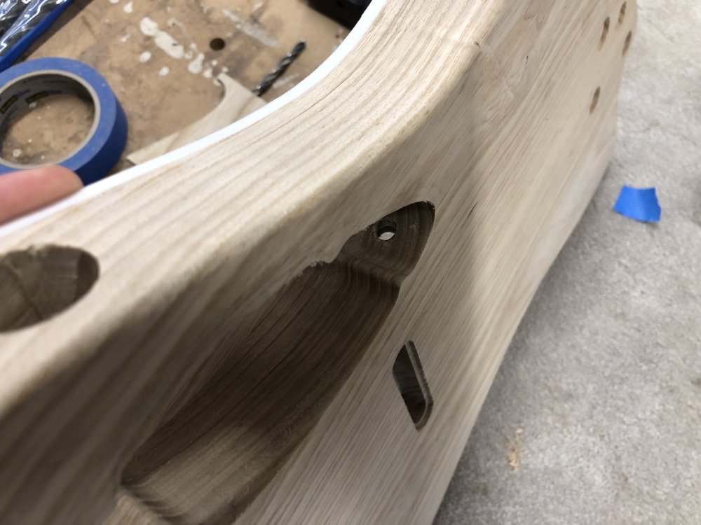A view from the back of the guitar body, showing the hole made from the pickup-cavity on the front to the control-cavity on the rear. You can see that the hole came through fairly centrally on the cavity.