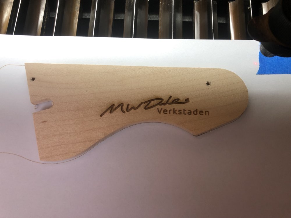 A photo of a bit of maple just the size of the headstock, sat on the paper guide, with 'M W Dales' signature and 'Verkstaden' etched into it.