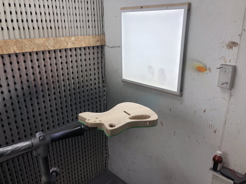The guitar is show in the spray-booth, mounted on the spraying jig that lets you rotate it as you work.
