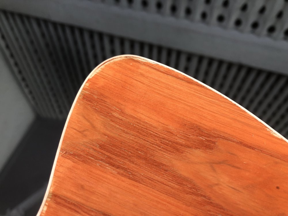 Another shot of the orange-stained guitar body, but there's clear areas where the stain didn't get to the wood along the top corner.