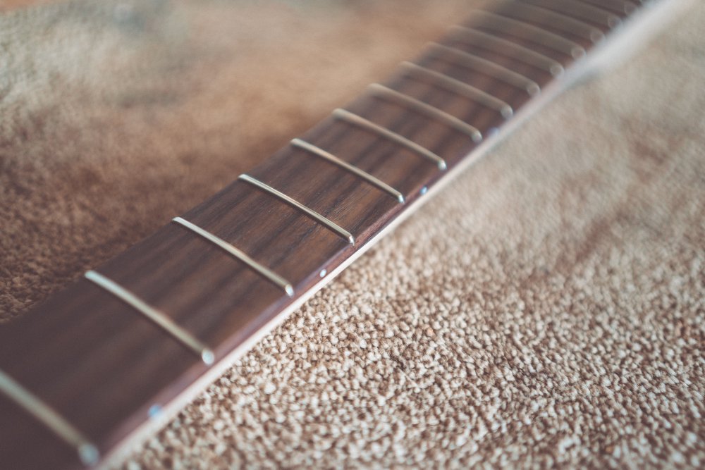 An 'artsy' low depth-of-field shot of the guitar neck, showing just one fret in focus, with all the rest of the neck in soft focus.