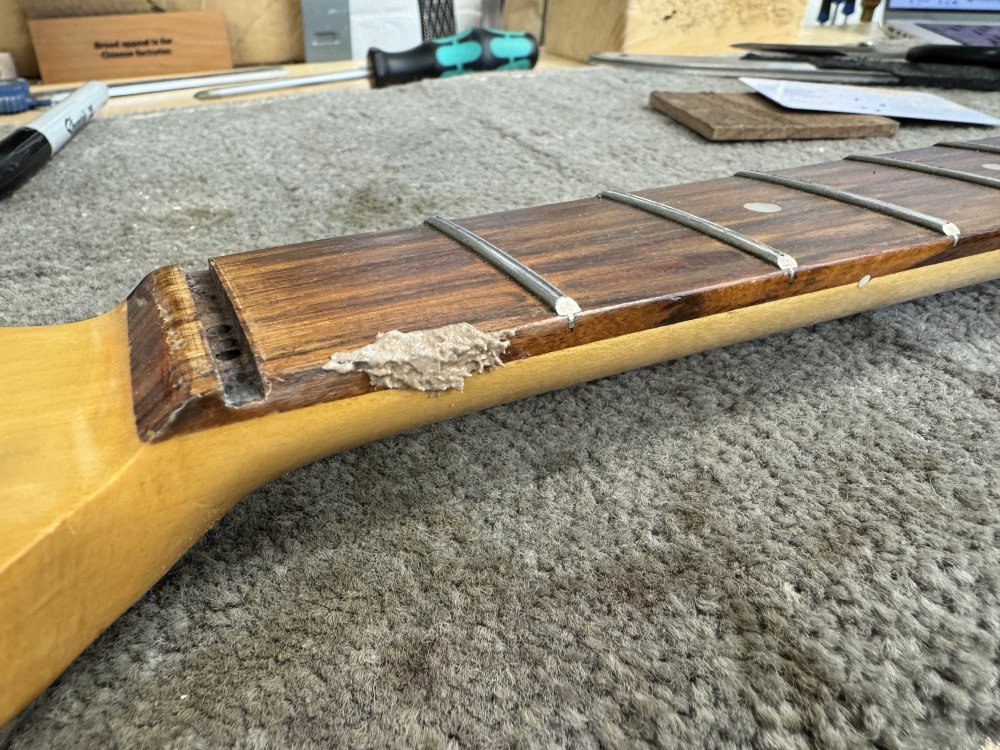 A close up of the neck again, with some goop that looks a bit like tuna-mayo on it, but is in fact rosewood-dust and wood-glue.