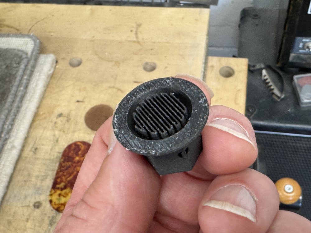 A photo of the underside of one of the knobs, showing that where there should be a gap for the potentiometer to fit there is a band and forth pattern of printer material.